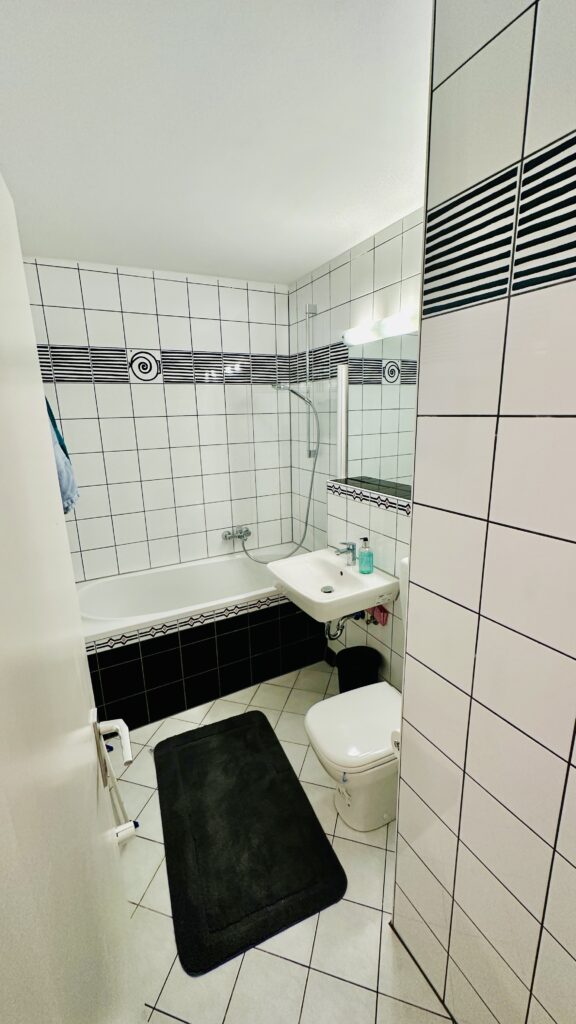 Helles Badezimmer im Oststadt Apartment Karlsruhe mit Badewanne, Dusche und Waschbecken