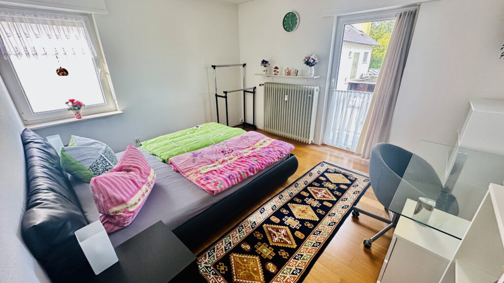 Schlafzimmer mit Queen Size-Bett und Balkon in Daheim am Wasserturm