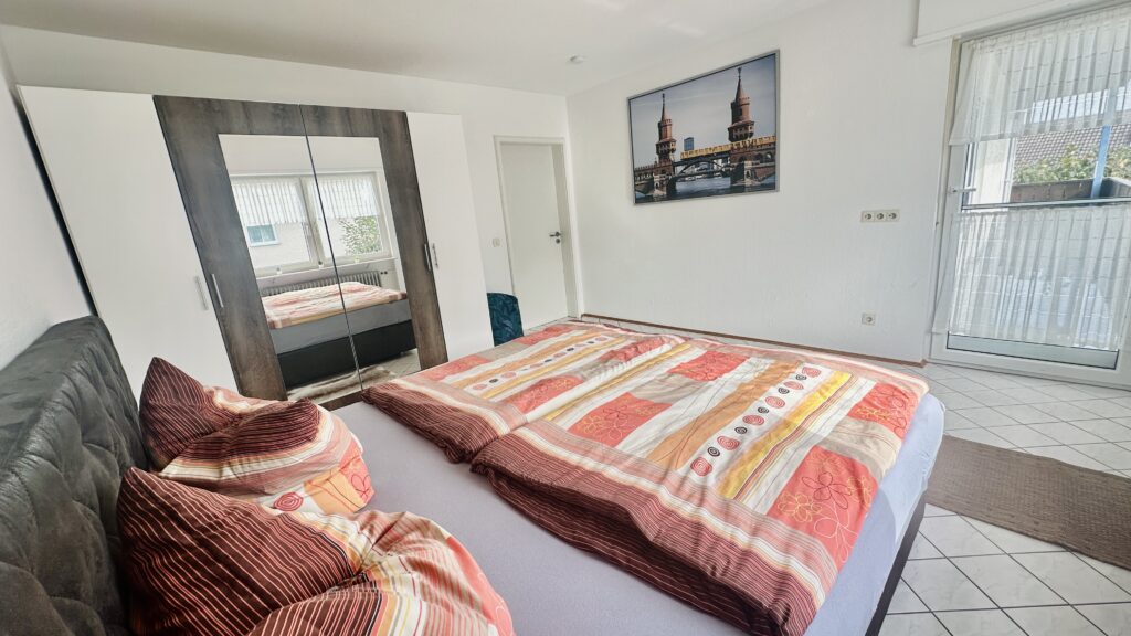 Schlafzimmer mit Bett und Schrank in Daheim am Wasserturm