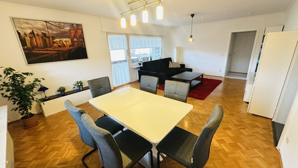 Daheim am Wasserturm – Wohnzimmer mit Balkon Alt-Text: Wohnzimmer mit Balkonzugang in Daheim am Wasserturm Untertitel: Direkter Zugang ins Freie Beschreibung: Vom Wohnzimmer gelangst du direkt auf den großzügigen Balkon.